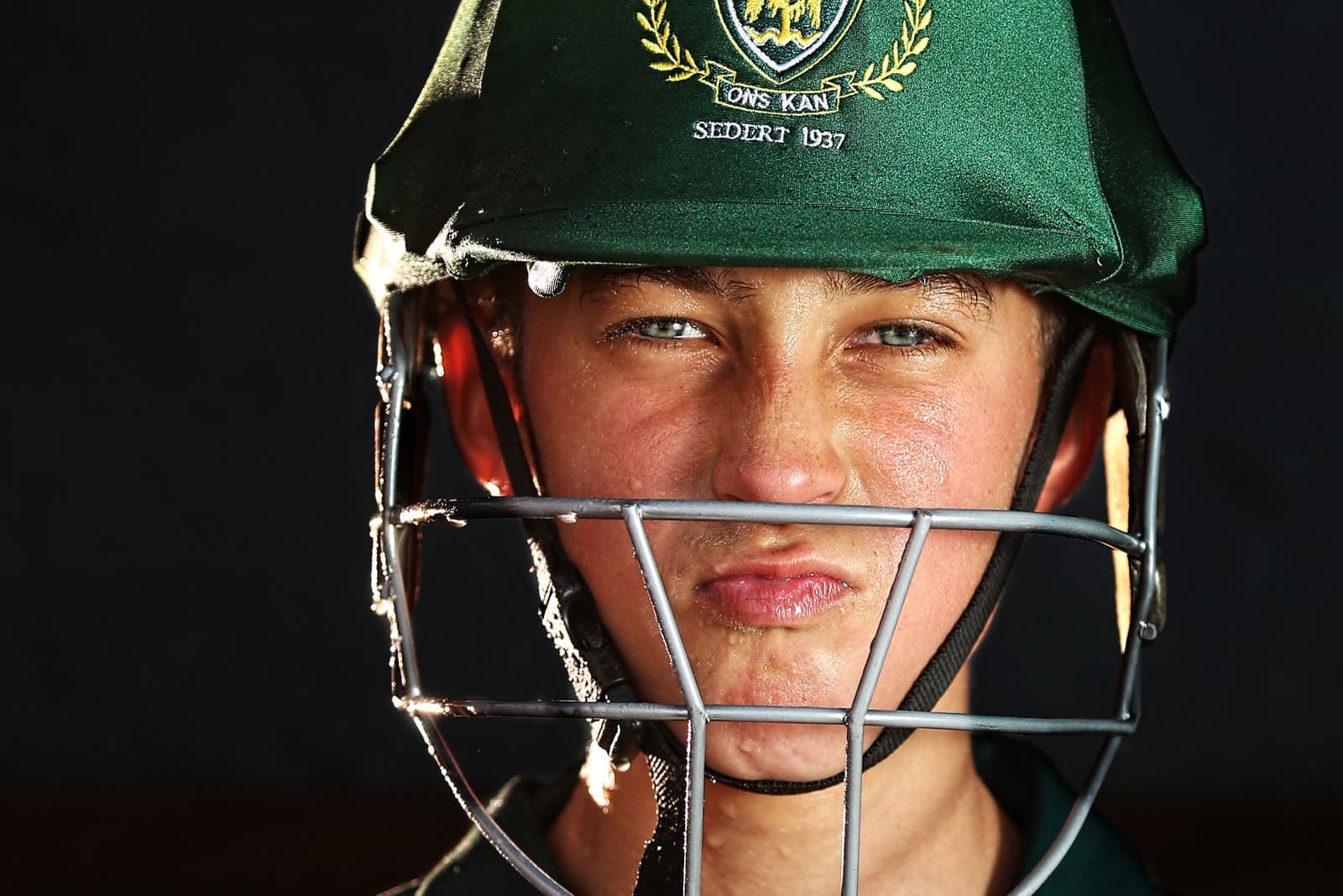 Close-up of a young cricketer wearing a batting helmet