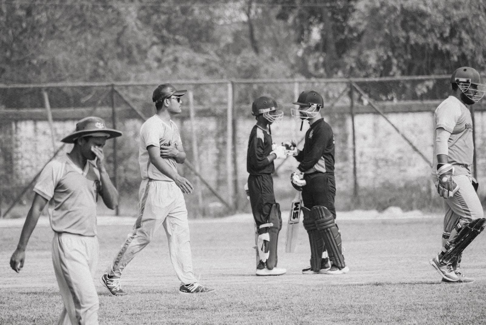 Cricket players interacting on the field between overs