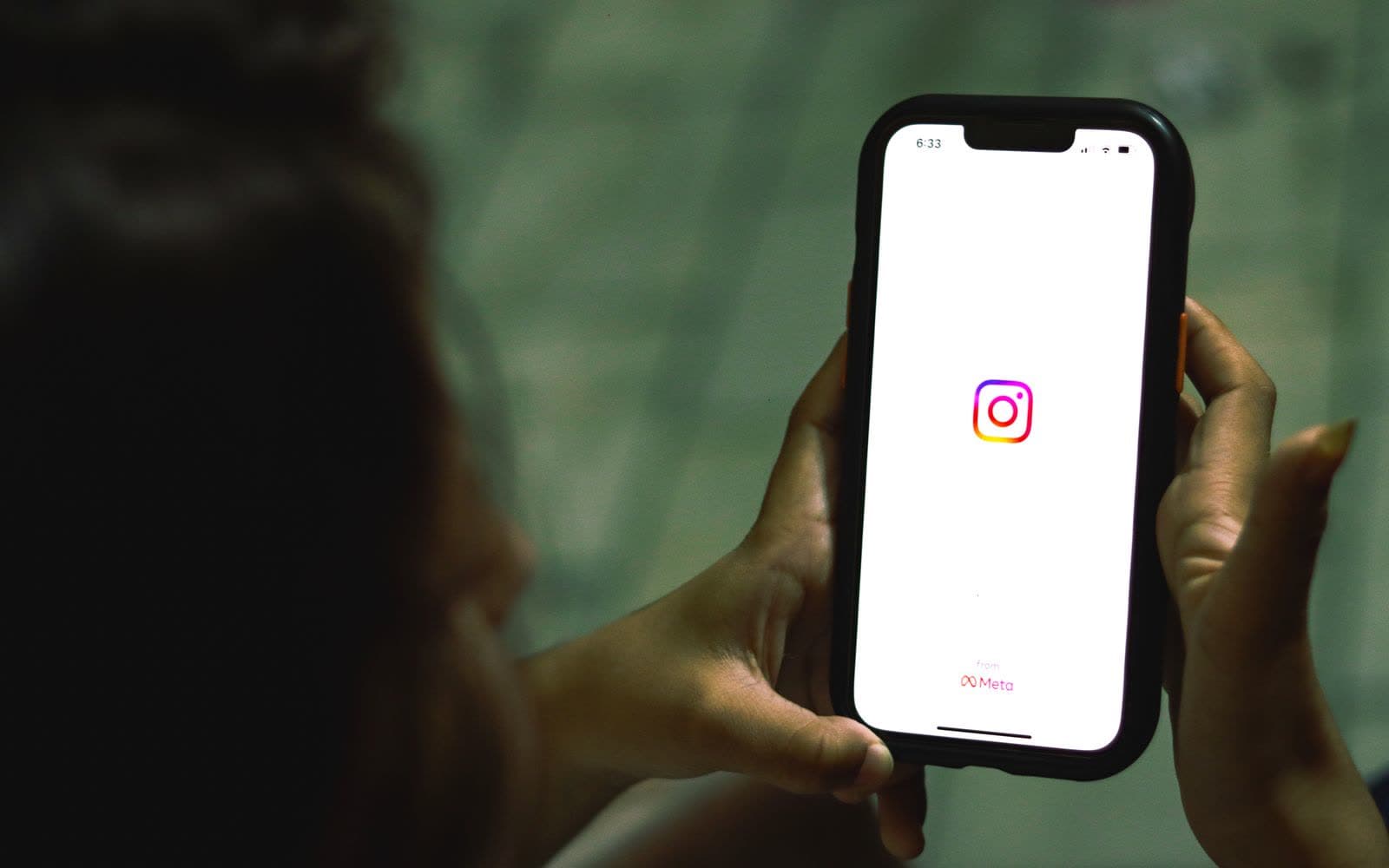 Close-up of a hand holding a smartphone with the Instagram app open