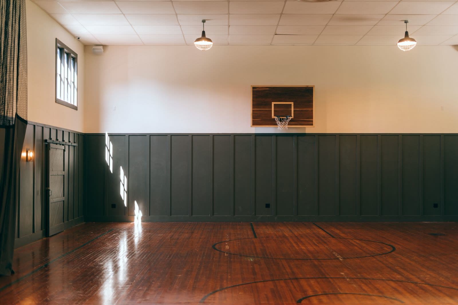 Empty indoor sports court with warm lighting and polished wooden floor