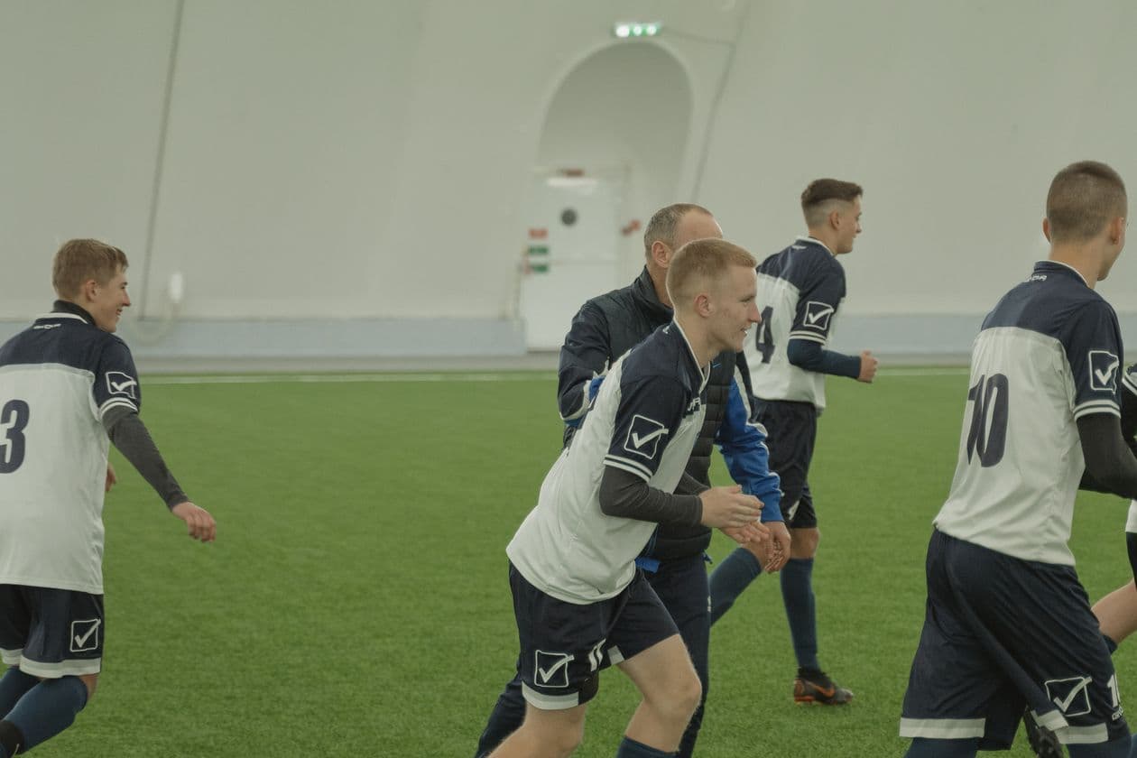Young soccer team practicing together on indoor artificial turf during a training session
